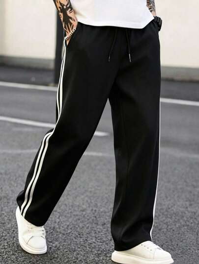 بنطلون رياضي رجالي أسود واسع الساق، بنطلون طويل بأسلوب الشارع العتيق مع خطوط بيضاء مزدوجة على الجانبين، قصة فضفاضة، مناسب لملابس الشارع الحضرية والخروجات اليومية والرياضة، فصل الخريف