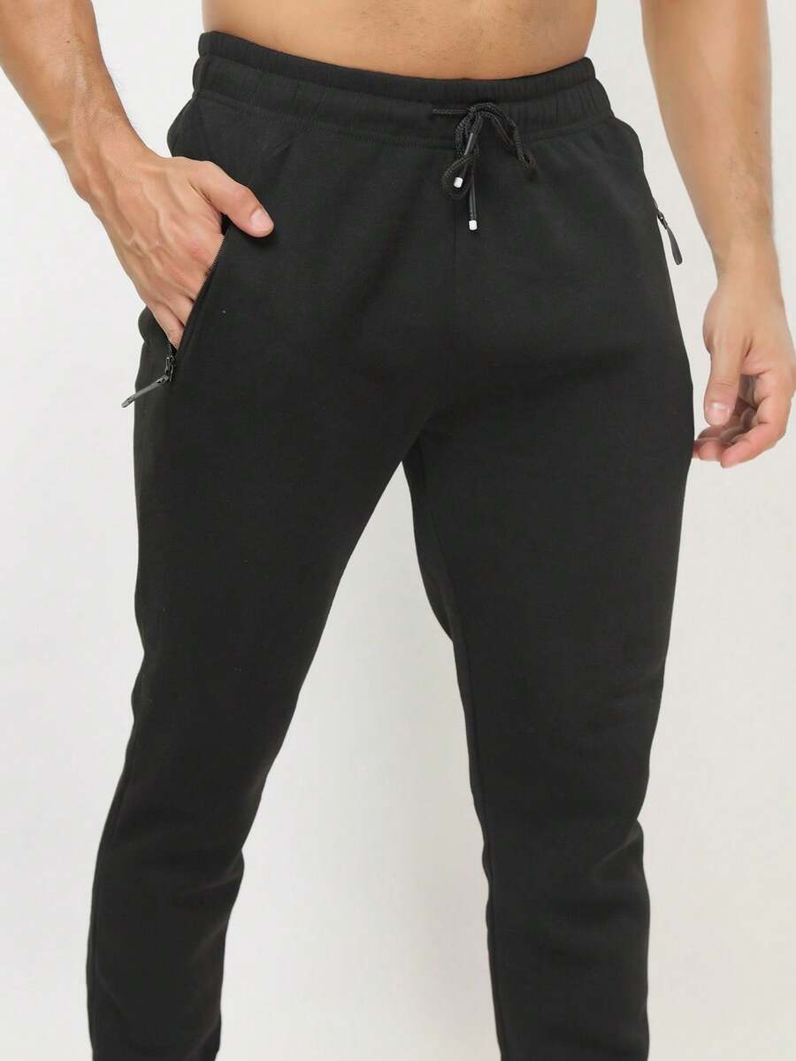 Calça de moletom preta básica casual masculina, com bolsos com zíper e cordão, em tecido levemente elástico. - Preto - Visão 1