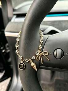 1 pieza Cadena de volante de coche con dije de letra inicial de concha y lazo de strass en tono dorado, estilo bohemio, cadena de metal para decoración interior de automóvil, accesorio ornamental personalizado para vehículo - A - Ver 19