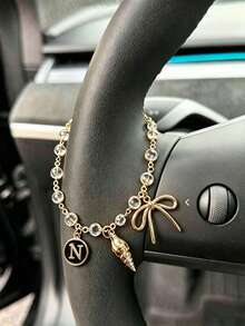 1 pieza Cadena de volante de coche con dije de letra inicial de concha y lazo de strass en tono dorado, estilo bohemio, cadena de metal para decoración interior de automóvil, accesorio ornamental personalizado para vehículo - A - Ver 14