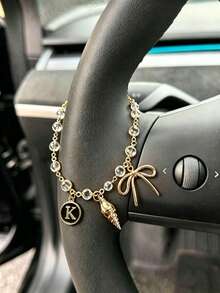 1 pieza Cadena de volante de coche con dije de letra inicial de concha y lazo de strass en tono dorado, estilo bohemio, cadena de metal para decoración interior de automóvil, accesorio ornamental personalizado para vehículo - A - Ver 5