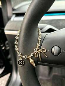 1 pieza Cadena de volante de coche con dije de letra inicial de concha y lazo de strass en tono dorado, estilo bohemio, cadena de metal para decoración interior de automóvil, accesorio ornamental personalizado para vehículo - A - Ver 10