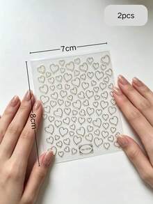 2片裝高級金箔細線愛心美甲貼紙，多款鏤空愛心款式，精緻金邊輪廓，柔美優雅，透明薄膜，自黏免照燈，自然貼合真甲與穿戴甲，不易脫落，百搭裸色與純色美甲，韓系極簡富家女風，適合通勤、約會、婚禮，防水耐用持久，新手DIY輕鬆上手 - 彩色 - 查看 7