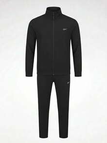 Conjunto Reebok Tracksuit Vector para Hombre Chamarra Cierre Completo y Pantalón Deportivo de Ajuste Regular Tejido Suave Logotipo Vector Minimalista Calentamientos Entrenamiento y Casual - Negro - Ver 1