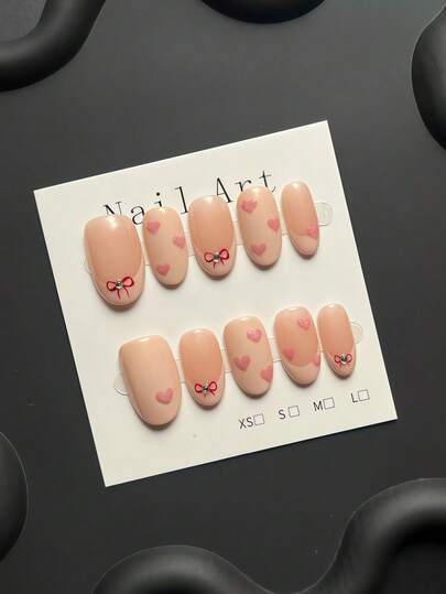 10-Piece Handmade Press-On Nail Kit, Short Oval Shape | Nude Base, Sweet And Innocent Style, Hand-Painted Mini Red Bow And Glittery Heart Embellishments. Perfect For Everyday Commuting And Dates. The Best Gift For Ladies And Girls.