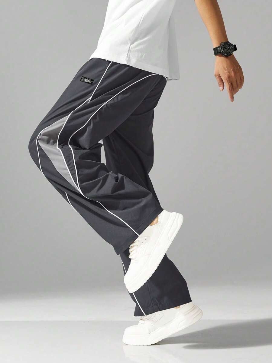 Pantalones deándal holgados estilo calle para hombre, cintura con cordón, pantalones casuales de color contrastante, adecuados para uso casual, ribete de borde unido, cintura elástica cómoda con cordón, estilo deportivo, pantalones de pierna recta holgada y ancha de moda casual de color contrastante.