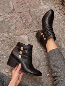 Botín elegante de mujer, piel genuina, con tacón medio, detalle de botones metálicos y ajuste tipo agujeta. Disponible en colores negro y café. Ideal para looks casuales o formales - Negro - Ver 1