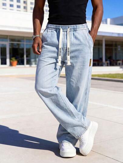 Celana Jeans Pria dengan Tali Serut dan Pinggang Elastis, Warna Biru Pudar Bergaya Vintage, Potongan Lurus Longgar, Cocok untuk Menciptakan Tampilan Santai dan Nyaman untuk Perjalanan dan Aktivitas Sehari-hari.