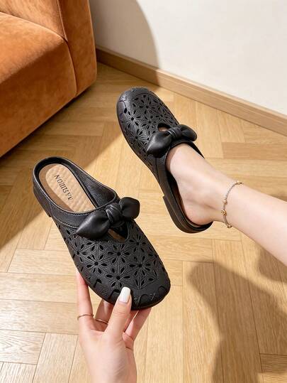 Sandales pour femmes respirantes avec décoration de nœud papillon ajouré, sandales plates confortables et durables, sandales noires d'été à la mode pour la plage, les vacances, la maison et l'extérieur, chaussures pour femmes à bout fermé perforées, pantoufles plates à enfiler à bout fermé