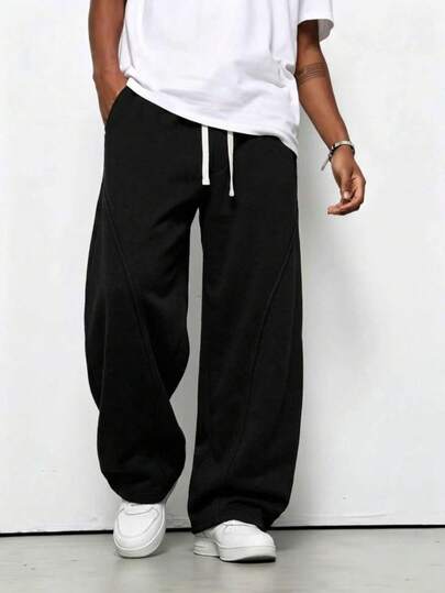 Pantalon de survêtement homme noir automne 1 pièce, coupe ample et fluide, jambes incurvées et segmentées, taille haute élastique avec double cordon de serrage blanc, empiècements patchwork en diagonale, longueur au sol. Confortable à porter, idéal pour les trajets quotidiens, les loisirs à la maison et les activités sportives décontractées en automne/hiver.