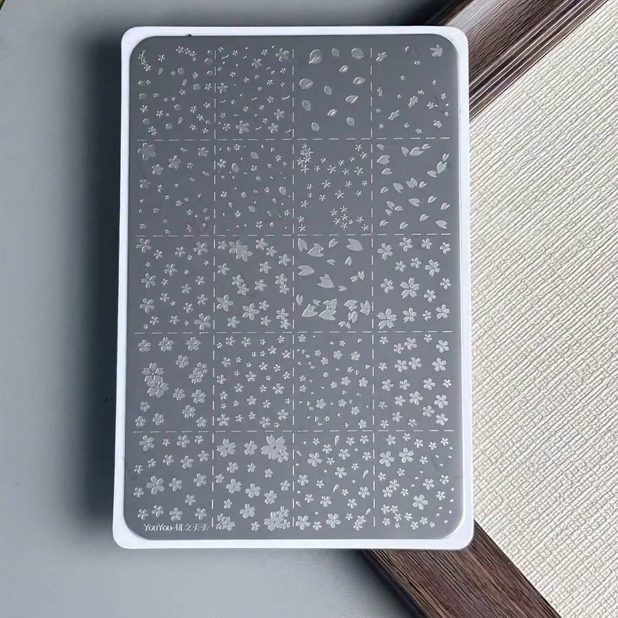 1片多功能桃花鋼板全覆蓋小花紋，灰色背景配白色線條營造清晰雕刻素描效果，桃花鋼面具有鮮明定義的雕刻線條與立體質感，一次壓印油墨即可覆蓋整個指甲表面且不易漏印，紋理轉移清晰，附透明塑料刮板，易於清潔不傷手，適用於全甲美甲與局部應用