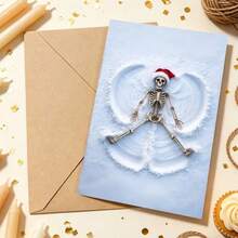 OBOVAY Skull Snow Angel Christmas Greeting Card, Funny Skeleton Wearing Santa Hat Making Snow Angel On Snowy Ground, Cool Gothic Style Holiday Design White Snow Background Unique Black Humor Style Greeting Card - A - View 2