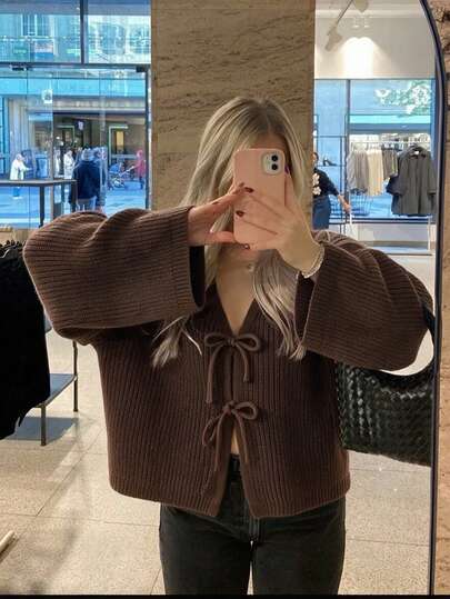 كارديجان نسائي جديد للخريف بياقة على شكل حرف V، بأسلوب كاجوال جامعي، تصميم ربطة فيونكة، قماش محبوك بنسيج بارز مع أكمام فضفاضة، قصة واسعة مناسبة للارتداء اليومي في بداية الخريف أو نهاية الصيف، ملابس الحرم الجامعي أو مناسبات العطلات الخفيفة، يمكن ارتداؤه بمفرده مع شورت دراجة أسود وحذاء رياضي ضخم