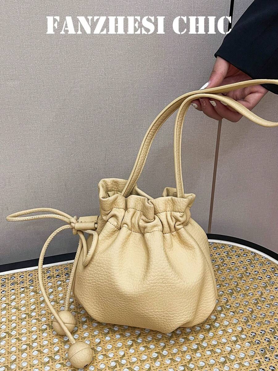 側邊皮革繩球吊飾裝飾肩背包，細肩帶支持肩背與斜背穿搭，小包可收納口紅、鑰匙及其他個人物品，抽繩收口，溫柔韓風迷你雲朵水桶包，適合年輕女性約會、購物、日常出遊與旅行 - 黃色 - 查看 1