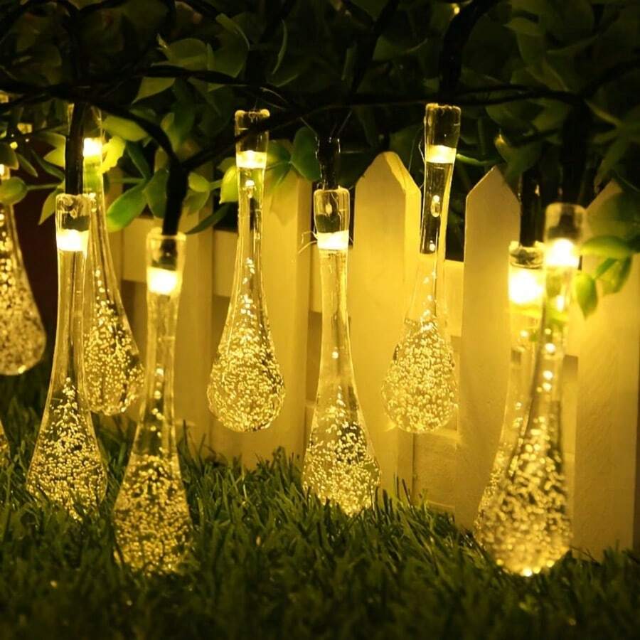 Warm Light Solar Water Drop String Lights, Available In 5M20LEDs, 7M50LEDs, 12M100LEDs Three Sizes, Exquisite Transparent Water Drop Shape, Warm Light Radiates From Inside The Water Drops, Soft Light Diffuses, Elegant And Fresh Style. Solar Powered, Automatically Stores Sunlight Energy During The Day, Automatically Turns On At Night, No External Power Supply Needed, Eliminates Wiring Hassle, Easy Hanging Installation. Multiple Light Dynamic Modes, Soft And Soothing Warm Light