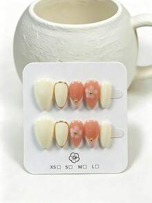 10片手工穿戴甲 短杏仁形 秋冬款 乳白色與裸粉色底色 金色邊緣法式尖端 手繪淡粉色花卉與金色珠飾 柔美甜美秋季氛圍 適合秋季約會、氛圍感穿搭、街頭穿搭 含全套美甲工具組 完美獨家禮物 - 白色 - 查看 2