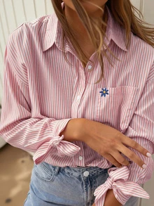 优雅的黄白条纹女式衬衫，正面有花卉图案，袖口有蝴蝶结，是春秋季节的完美选择