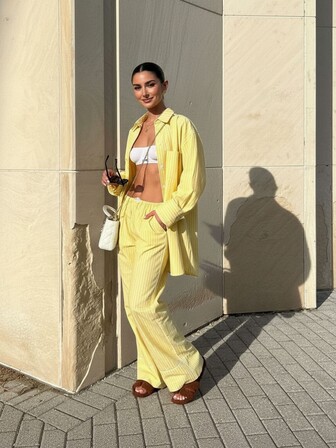 A Two Pieces Set Of Loose Striped Pocket Shirt And Wide-Leg Pants For Women's Casual Commuting In The European And American Style. The Highlight Design Is The White Border On The Hem And Side Of The Pants. It Is Suitable For Fashionable Casual Commuting Daily And Urban Styles