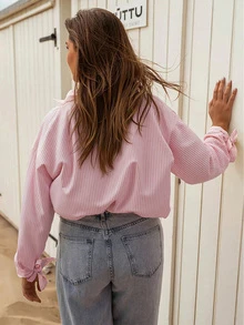 优雅的黄白条纹女式衬衫，正面有花卉图案，袖口有蝴蝶结，是春秋季节的完美选择