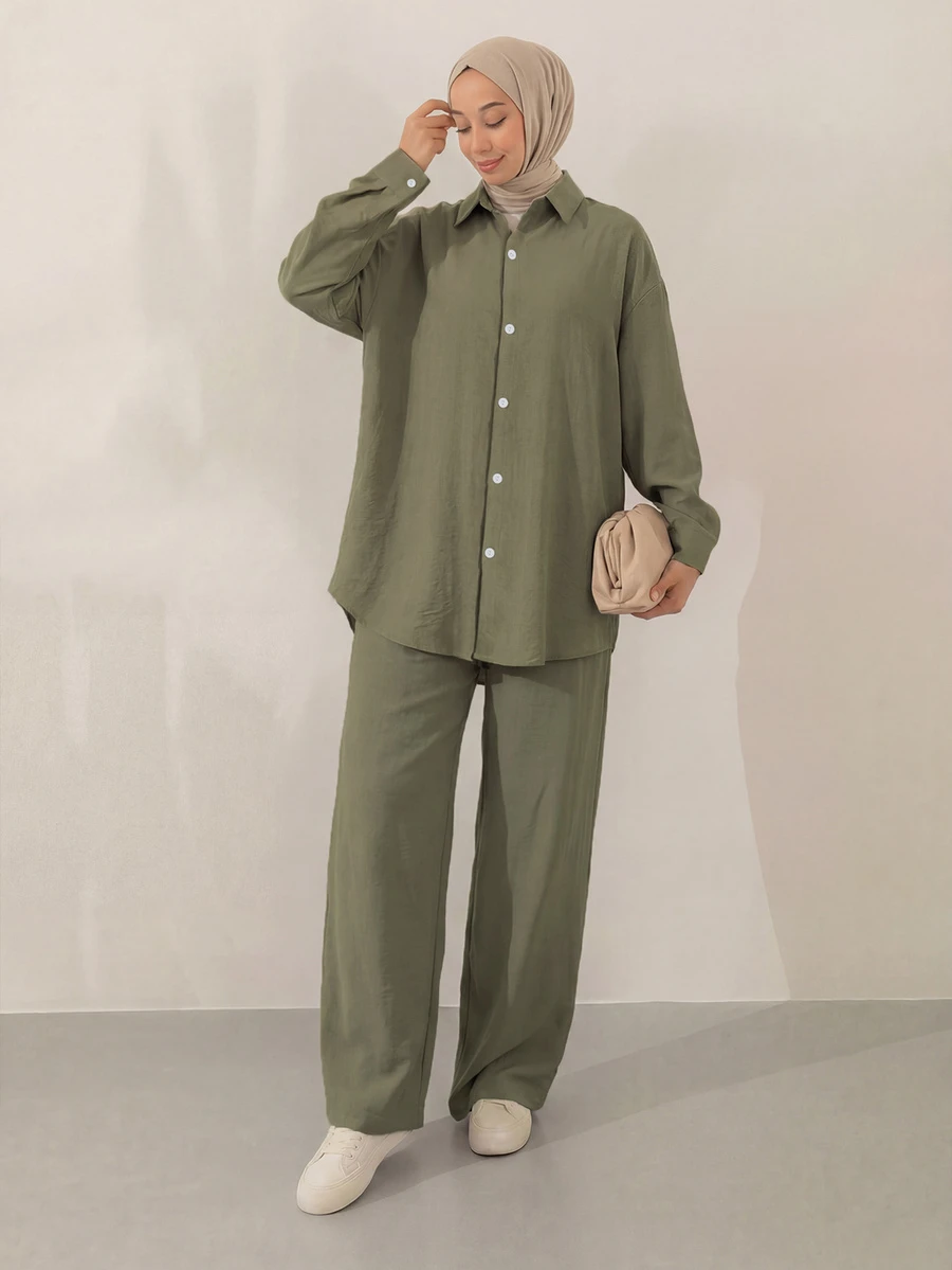 女士休闲套装，简约优雅风格，包括一件翻领纽扣衬衫和一条阔腿裤，采用无弹力面料制成，带有口袋和褶裥细节。