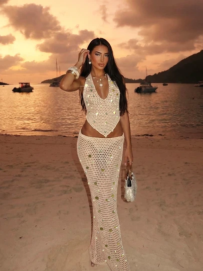 Bộ đồ hai mảnh dành cho nữ năm 2026, phong cách Bohemian mới, gồm áo dệt kim cổ chữ V đính sequin và họa tiết vỏ sò, kết hợp với chân váy dài xuyên thấu khoét hở gợi cảm.