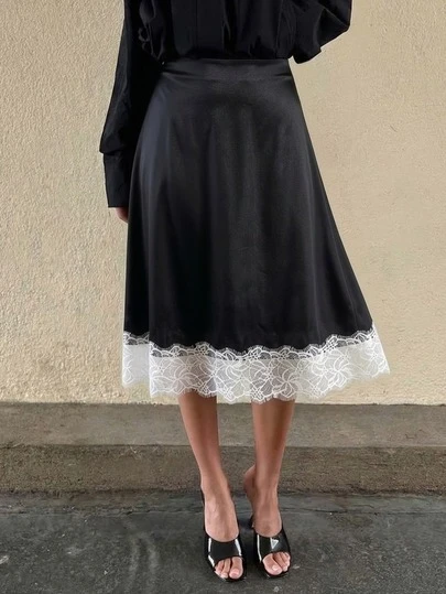 Saia feminina elegante vintage em cetim preto com detalhes em renda branca na barra, estilo casual chique.