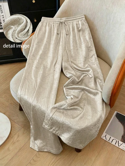 新款夏季百搭休闲纯色褶皱梭织面料抽绳裤，适合日常、海滩、度假、派对、机场、舞台和音乐会等场合穿着，表面光泽亮丽。