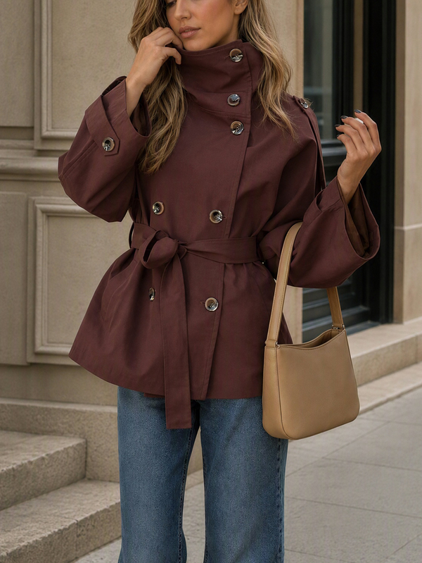 Moderiktig dubbelknäppt trenchcoat för kvinnor i regular längd, tillverkad i vävt tyg med trattkrage och sänkta axlar, för en modern höstlook