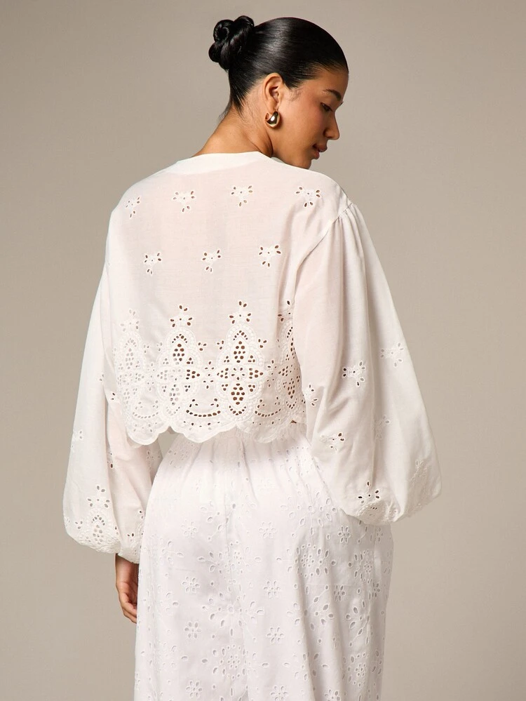 Blusa branca com bordado inglês e mangas bufantes.