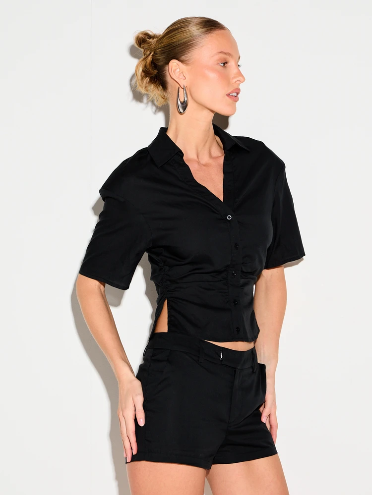 KIZN Chemise courte à manches courtes et col boutonné pour femmes avec détails d'épaulettes. Top court de style lin