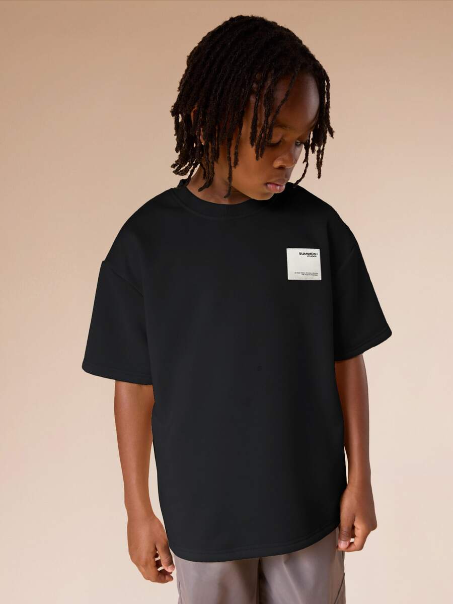 SUMWON Camiseta de verano oversize para niños con parche de logo blanco, camiseta de manga corta informal para preadolescentes - Negro - Ver 1