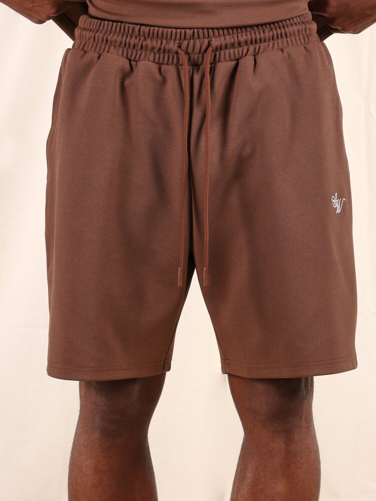 Brązowy T-shirt z krótkim rękawem i pasujące do niego spodenki. Dwuczęściowy, swobodny komplet z okrągłym dekoltem i luźnym krojem zapewniającym codzienny komfort.