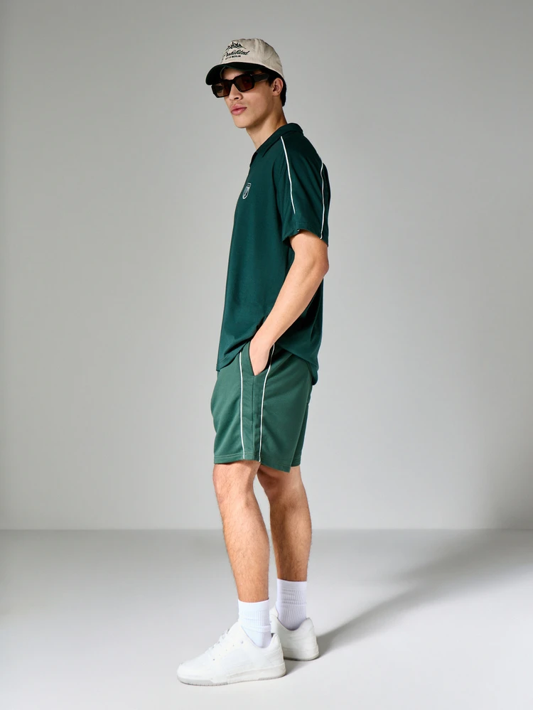 Conjunto a juego de camisa polo y pantalones cortos en color verde bosque con detalles de ribete blanco, top de manga corta con cuello, ajuste de caja, conjunto informal de verano