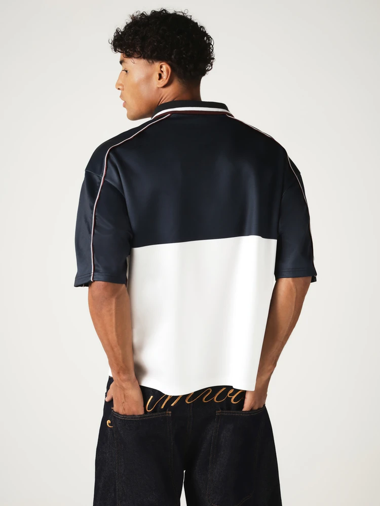 Polo décontracté ajusté avec col lacé, panneaux color block, broderie et passepoil contrastant. Tenue de jour de match de la Coupe du monde 2026, style sportif chic, maillot streetwear blokecore
