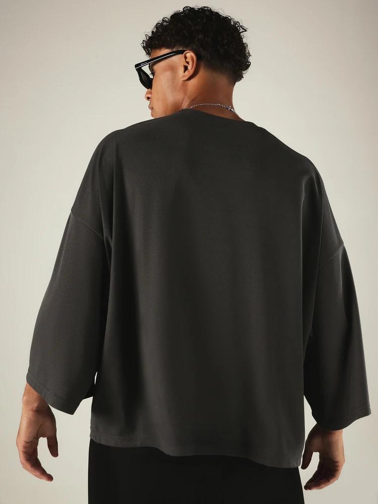 Maglietta casual in maglia a nido d'ape con collo a giro, maniche a 3/4 e taschino sul petto, vestibilità oversize e squadrata