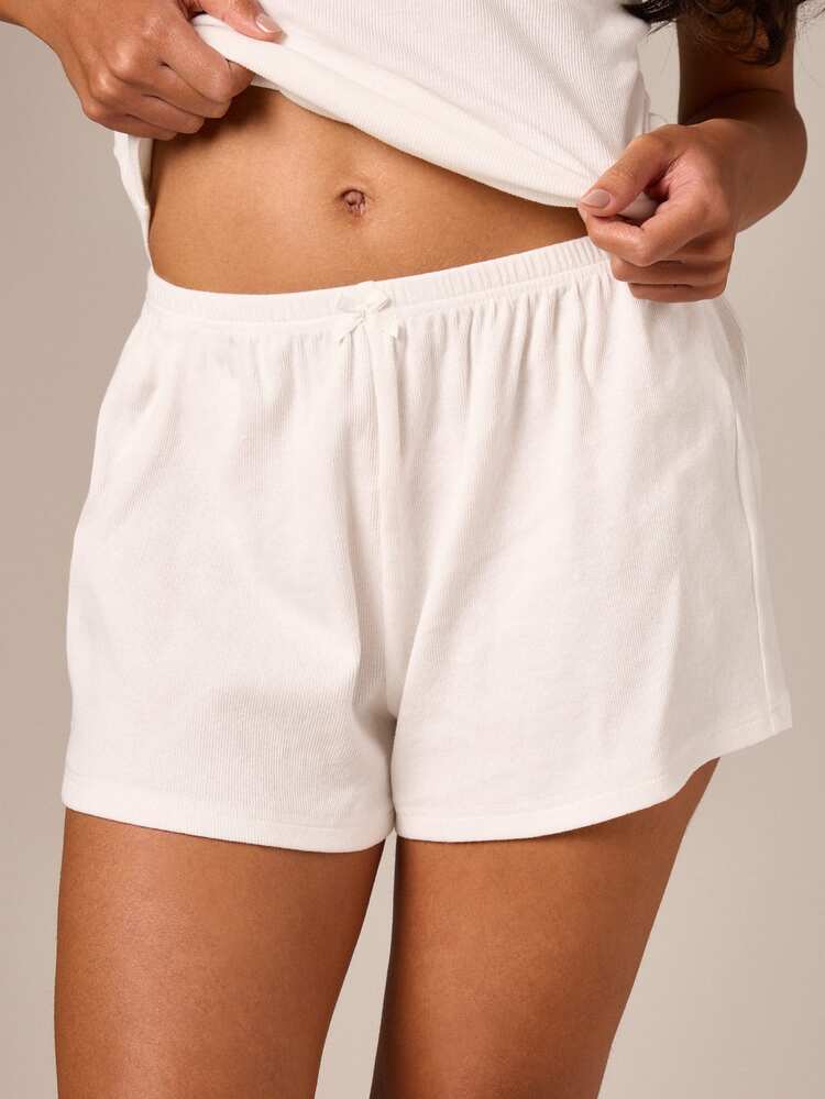Completo composto da canotta e pantaloncini a coste con bordo in pizzo.