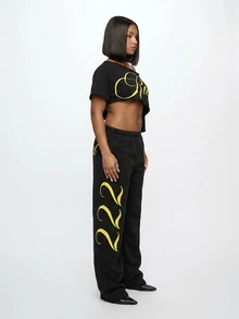 SUMWON WOMEN Off-Shoulder Crop Tee With Diagonal Raw Hem Cut And Gold Script Graphic Print - Black - View 7