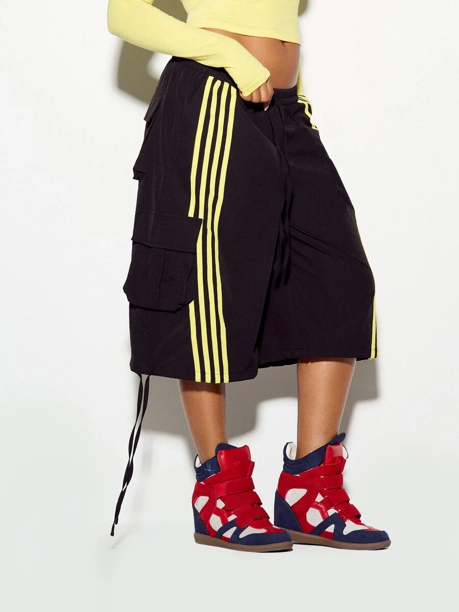 SUMWON WOMEN Celana kargo hitam model lebar dengan detail garis kuning mencolok di samping dan saku kargo, serta tali serut di bagian bawah. Gaya kasual jalanan. - Hitam - View 1