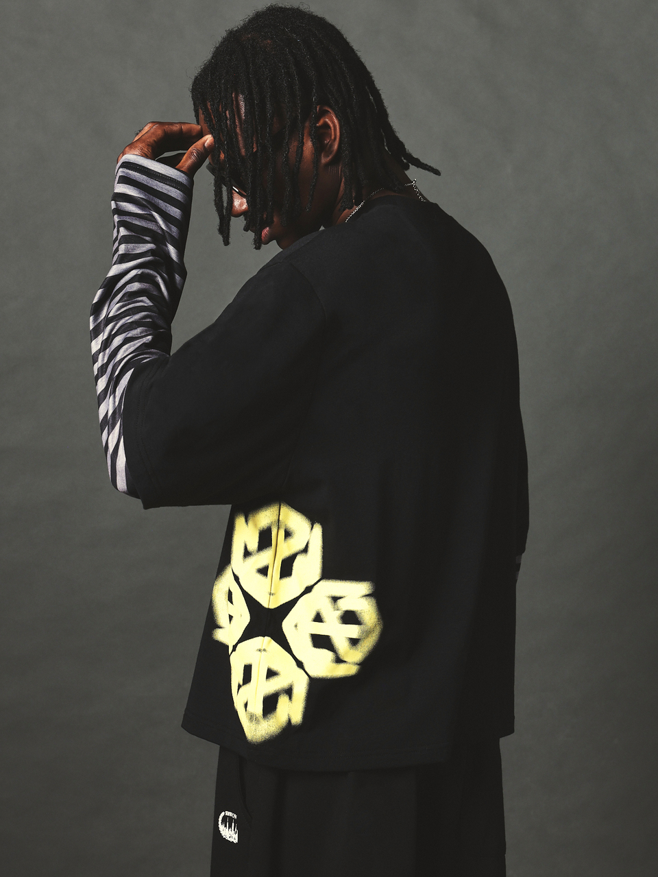 Camiseta Preta Oversized Boxy com Gola Redonda, Manga Curta, Ombro Caído, Estampa Gráfica de Logotipo em Spray Amarelo Vibrante nas Costas, Top Casual Estilo Street
