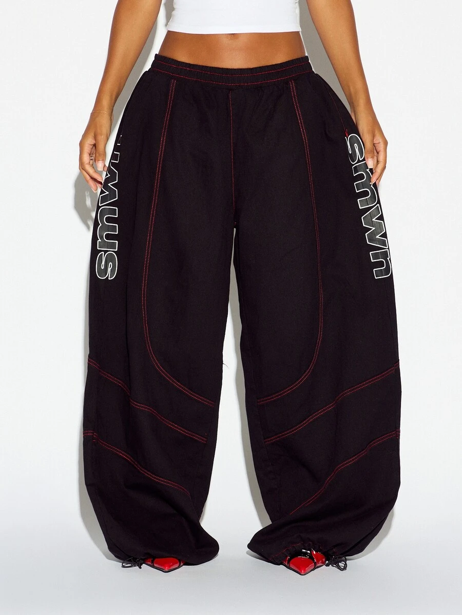 SUMWON WOMEN Oversized Baggy Casual Pants With Red Contrast Stitching Vertical Logo Leg Print And Elastic Ankle Drawstring Detail - Black - View 1