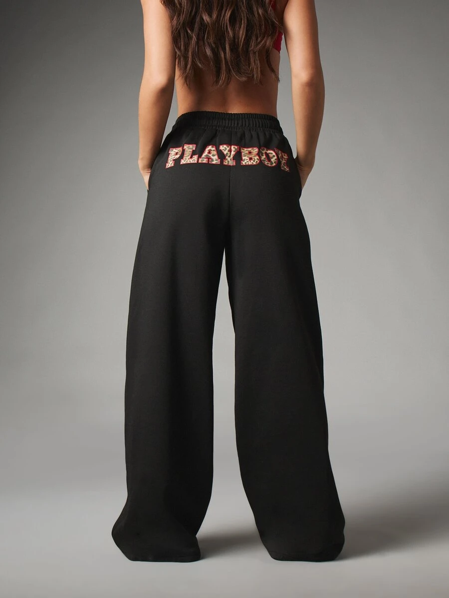 Missguided x Playboy بنطال رياضي واسع الساق من الصوف الناعم مع تطريز شعار الأرنب وطباعة نمر على حزام الخصر بتفاصيل نص جامعي وحبل شد - الأسود - مشاهدة 1
