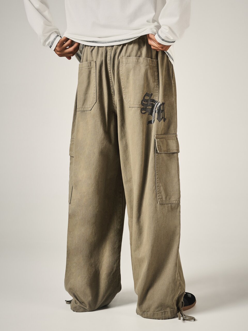 Pantalon cargo à jambes larges avec logo brodé, taille élastique, cordon de serrage, finition lavée, poches utilitaires, longueur complète, style de rue