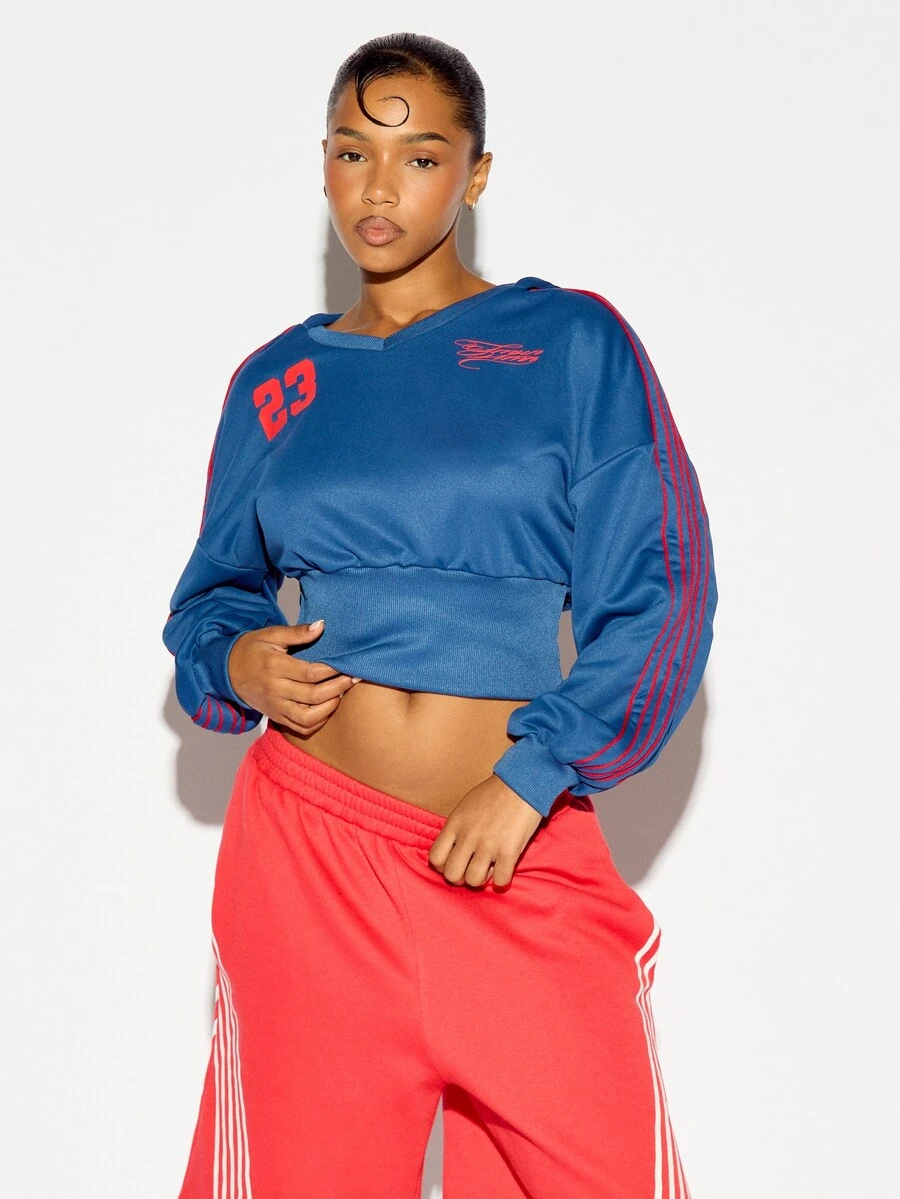 SUMWON WOMEN Sweatshirt Crop Kerah V dengan Cetakan Nomor 23 di Dada, Detail Garis Merah pada Lengan, Kelim Berusuk, Gaya Jersey Sporty - Biru - View 1
