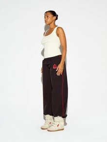 SUMWON WOMEN Oversized Wide Leg Nylon Track Pants With Red Side Piping And Embroidered Sheild Logo Detail Low Rise Full Length - Black - View 2