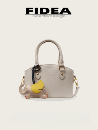 新款时尚女士手提贝壳包，简约别致纯色 PU 皮革纹理设计，金属铆钉装饰搭配独特小象吊坠，可调节可拆卸舒适肩带，拉链开合，适合外出、购物、约会等多种场合