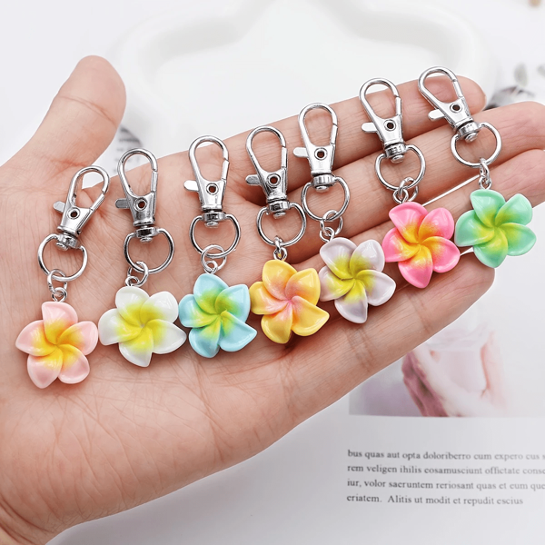 7 stuks schattige kleurrijke Frangipani-bloem sleutelhangers voor mannen en vrouwen, hars plumeria bedels met legering metaal, sleutelhangers met karabijnsluiting, decoratieve verjaardagscadeaukaarthouder sleutelhangerset voor tassen en autosleutels school auto-accessoires Goth Y2K