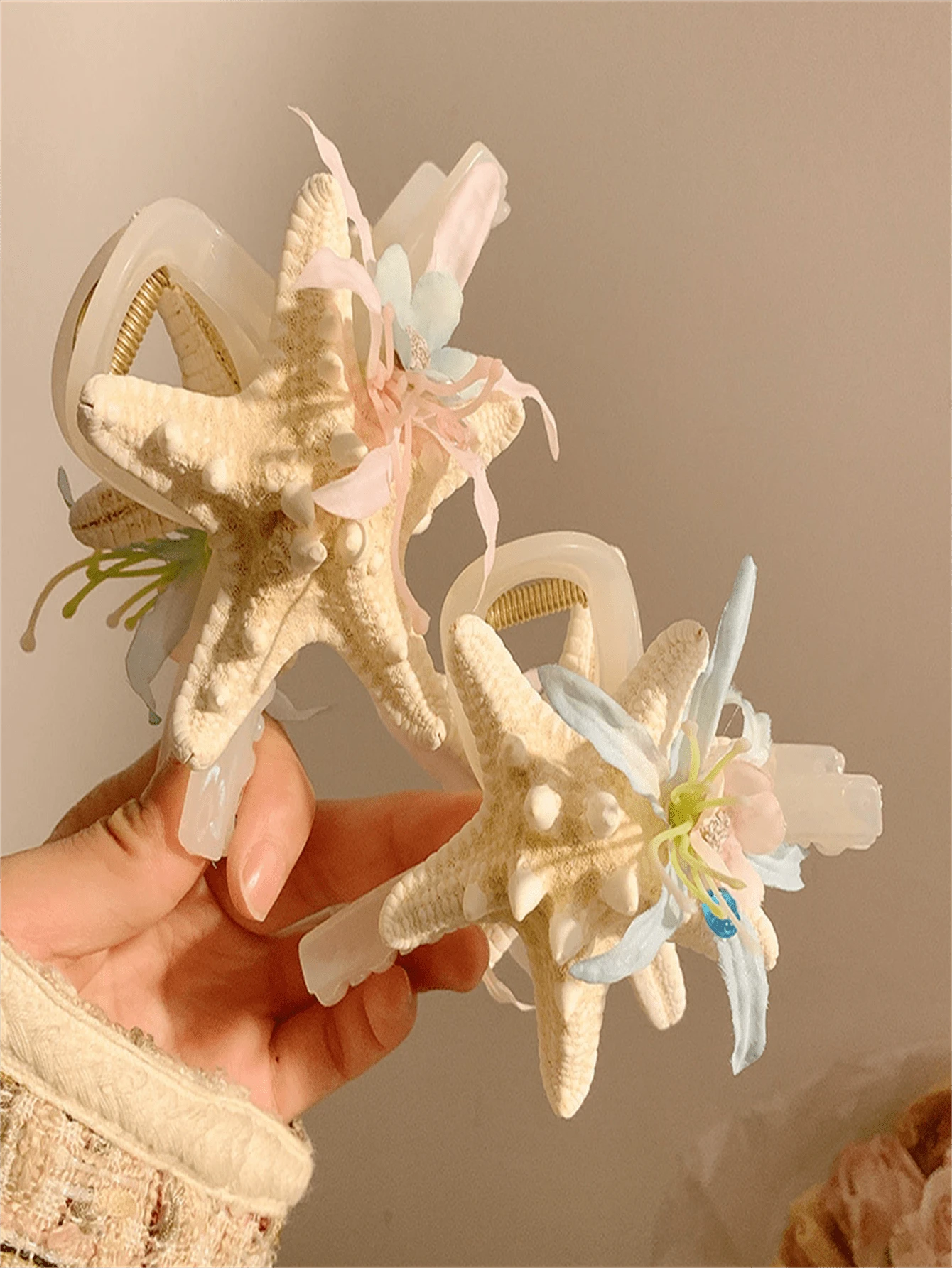 Um novo tipo de presilha de cabelo com flor de concha marinha, adequado para penteados durante férias na praia. Possui um formato de coque que fica na parte de trás da cabeça e vem com uma presilha de cabelo. O adereço de cabeça apresenta um design em forma de tubarão com um lado rosa e um lado azul. É um presente para as senhoras e adequado tanto para uso diário quanto para styling de moda.