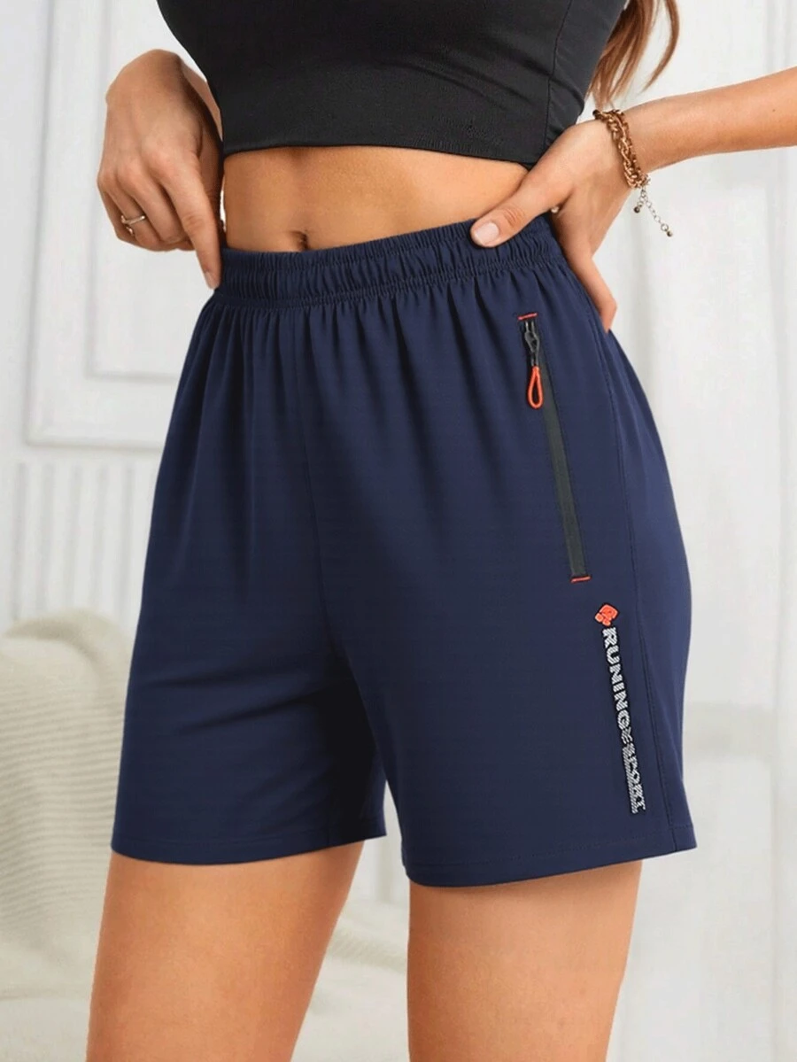 Pantaloncini da running leggeri e traspiranti da donna, di colore nero, con cerniera laterale, vita elastica con coulisse, tipografia a contrasto, adatti per palestra, allenamento e attività all'aperto