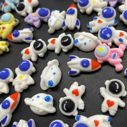 10/20/30/50 piezas Aleatorio Mini serie de cohetes espaciales, astronautas y planetas Adornos de resina planos traseros para manualidades DIY, scrapbooking, accesorios para el cabello, fundas de teléfono, llaveros y encantos para la fabricación de joyas DIY Materiales de accesorios