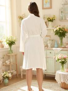 Biały szlafrok z paskiem, prosty, a zarazem wyrafinowany top do noszenia w domu, jesień